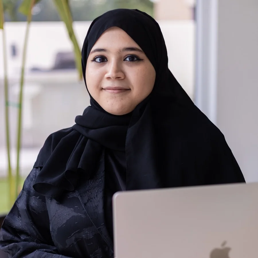 Bouchra Rebiai, Arabic SEO consultant in Dubai, at her laptop in warm natural light