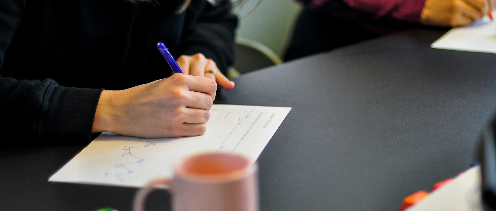 A participant working through an exercise on paper: the workshop runs as a hands-on lab, not a lecture