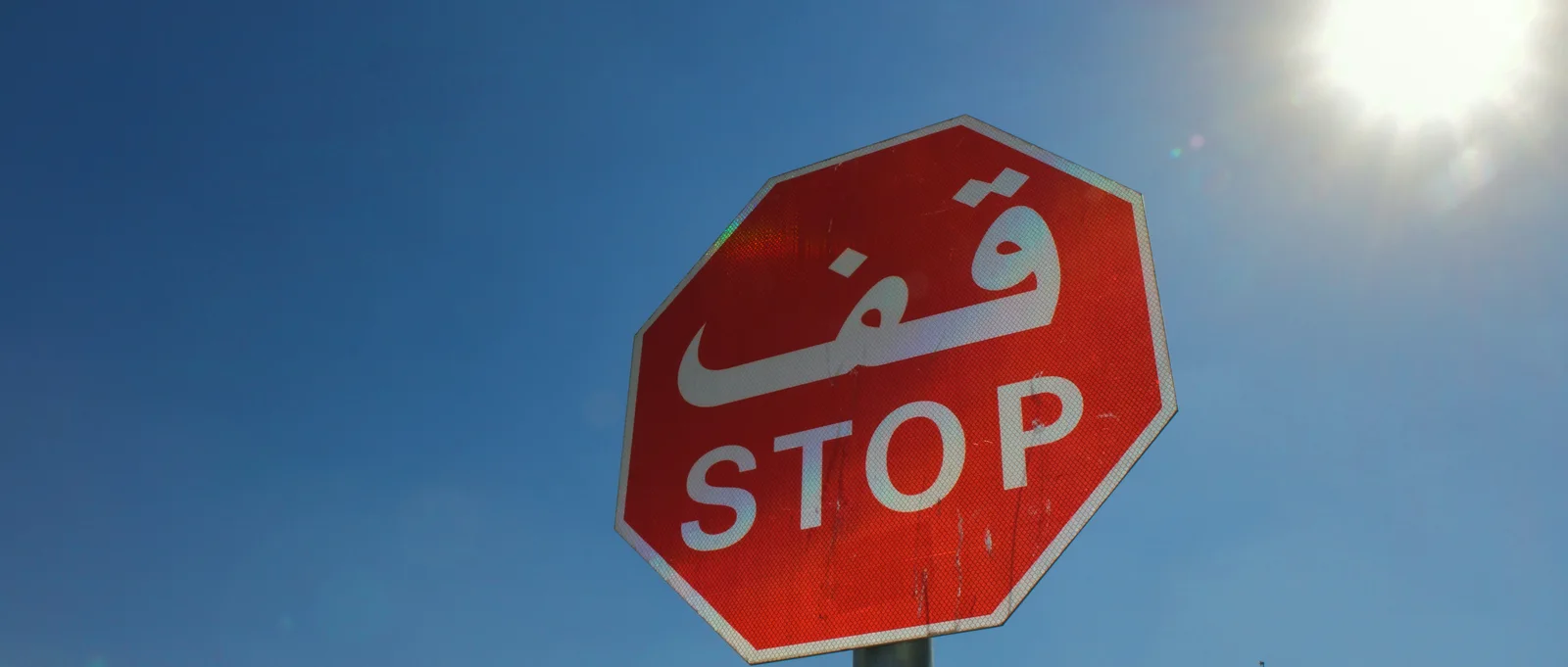 A Gulf stop sign reading قف above STOP: one word, rendered one way, everywhere it appears